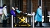 Trabajadores de salud transportan a un paciente usando una mascarilla en el NYU Langone Hospital en Manhattan, New York, durante el brote de coronavirus el 3 de mayo de 2020.