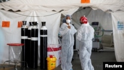 Des agents de santé discutent dans un service temporaire mis en place pendant la pandémie de coronavirus (COVID-19), à l'hôpital universitaire Steve Biko de Pretoria, en Afrique du Sud, le 19 janvier 2021. Phill Magakoe / Pool via REUTERS / File Photo