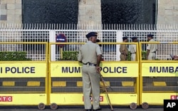 Policemen stand guard outside the Taj Mahal hotel in Mumbai. Multiple sites in the Indian city of Mumbai were attacked with bombs and gunfire in a coordinated terror attack that began on November 26, 2008, ( File)