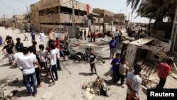 Iraqi residents gather at the site of a car bomb attack in the Kamaliya district in Baghdad, April 15, 2013. 