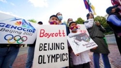 FILE - Children hold signs during a demonstration by a coalition representing Tibetans, Uyghurs, Southern Mongolians, Hong Kongers, Taiwanese and Chinese rights activists in Boston, June 23, 2021.