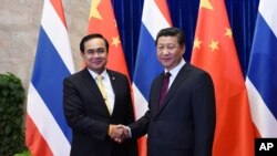 FILE - Thai Prime Minister Prayut Chan-ocha, left, shakes hands with Chinese President Xi Jinping, right, before a meeting at the Great Hall of the People in Beijing, Dec. 23, 2014.