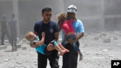  Syrian Civil Defense group known as the White Helmets carrying children after airstrikes hit a school housing a number of displaced people, in the western part of the southern Daraa province of Syria. (File)