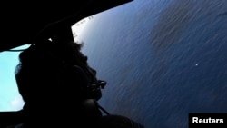 FILE - Co-pilot and Squadron Leader Brett McKenzie looks from the cockpit of a Royal New Zealand Air Force aircraft as they fly over the southern Indian Ocean.