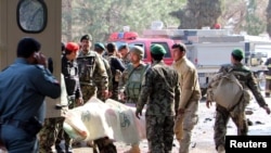 Əfqanıstan Milli Ordusunun əsgərləri intiharçı hücumu nəticəsində yaralananları təcili yardım maşınlarına daşıyır. 