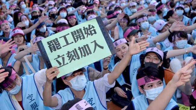 2019年6月21日一名台湾长荣航空公司的空服人员在罢工人群中手举“罢工开始立即加入”的标语牌。