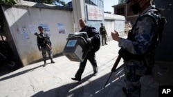 A Nepal election commission officer carrying ballot boxes heads to a polling booth in Katmandu, Nov. 17, 2013. 