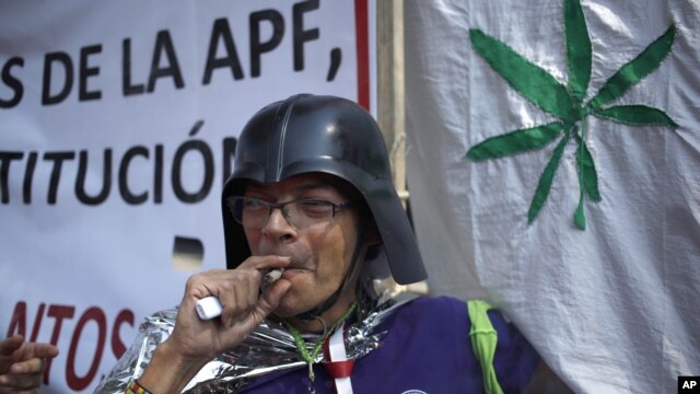 Un partidario de la legalización del uso recreaciones de la marihuana fuma frente a la Corte Suprema de México, el miércoles, 4 de noviembre de 2015.