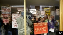 Protesters gather outside a press conference room during a special session at the North Carolina Legislature in Raleigh, N.C., Dec. 15, 2016. Republicans called their own special session to weigh legislation, some of which threatens the incoming Democratic governor.