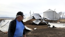 This photo taken March 12, 2020, near Rock Port, Missouri, shows tenant farmer Phil Graves examining grain storage bins that were destroyed in a 2019 flood.