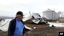 This photo taken March 12, 2020, near Rock Port, Missouri, shows tenant farmer Phil Graves examining grain storage bins that were destroyed in a 2019 flood.