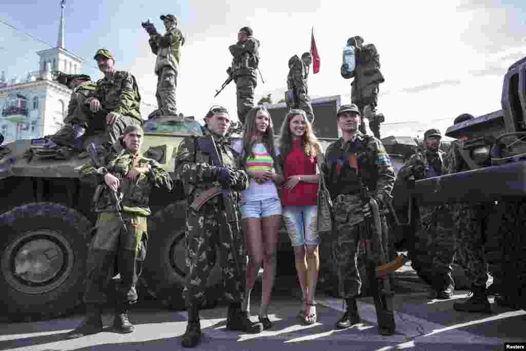 Women pose for a picture with pro-Russian rebels during a parade in the city of Luhansk, eastern Ukraine, Sept. 14, 2014.