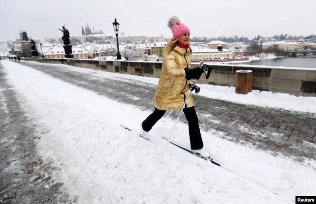 FILE - A woman cross-ｃountry skis across the medieval Charles Bridge in Prague, Czech Republic, February 9, 2021. (REUTERS/David W Cerny)