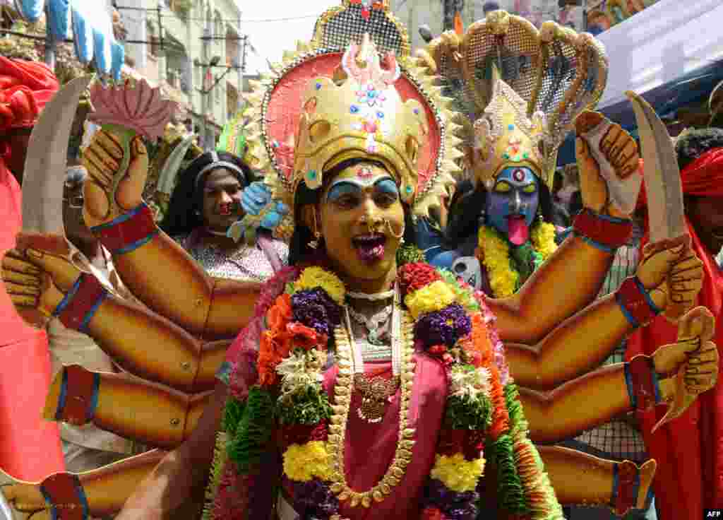 An Indian Hindu devotee dressed as the Hindu Goddess MahaKali performs in the street during the Bonalu festival at the Sri Ujjaini Mahakali Temple in Secunderabad, the twin city of Hyderabad, India. 