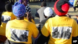 Supporters wearing t-shirts with a photo of former President Robert Mugabe, left,, at an election rally in Masvingo, Zimbabwe, July 14, 2018. 