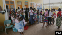 Women wait outside the family clinic. Jhpiego, a non-profit health organization, has folded screening into HIV-related health services, Boane, Mozambique, Nov. 20, 2014. (Gillian Parker/VOA)