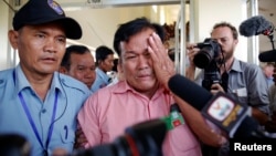FILE - Soum Rithy (C), who lost his father and three siblings during Khmer Rouge regime, is escorted after the verdict was delivered in the trial of former Khmer Rouge head of state Khieu Samphan and former Khmer Rouge leader Nuon Chea, at the Cambodia courthouse on the outskirts Phnom Penh, Aug. 7, 2014.