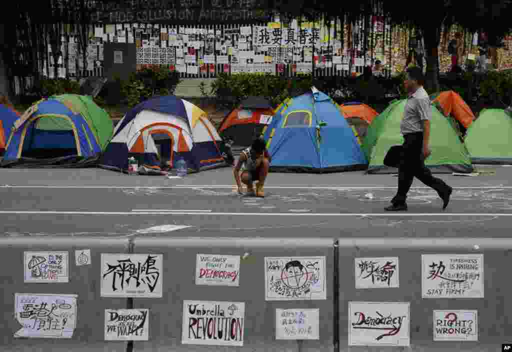 A protester draws on a main road in the occupied areas outside government headquarters, in Hong Kong&#39;s Admiralty, Oct. 10, 2014. 