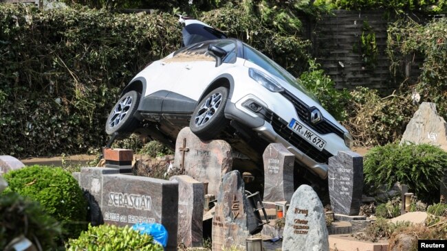 Një makinë shfaqet e ndalur mbi një varrezë pas tërheqjes së ujërave në Dernau, Gjermani