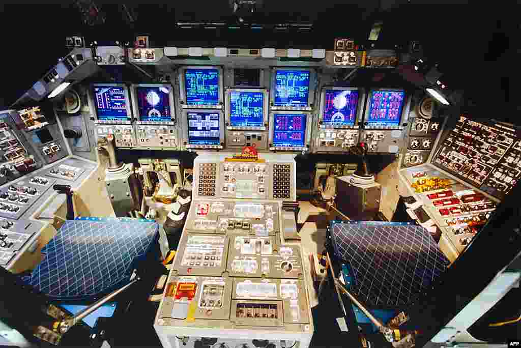 The cockpit of space shuttle Discovery is brightly lit as preparations are made for the shuttle's final power down. (NASA) 