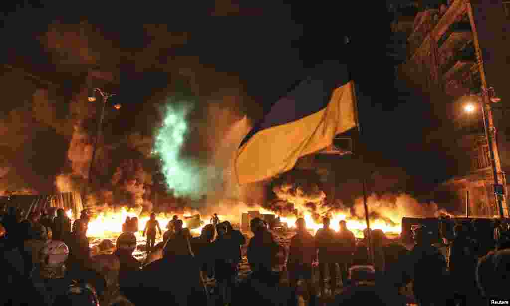 Pro-European integration protesters gather in front of burning tires during clashes with riot police in Kyiv, Jan. 23, 2014. 