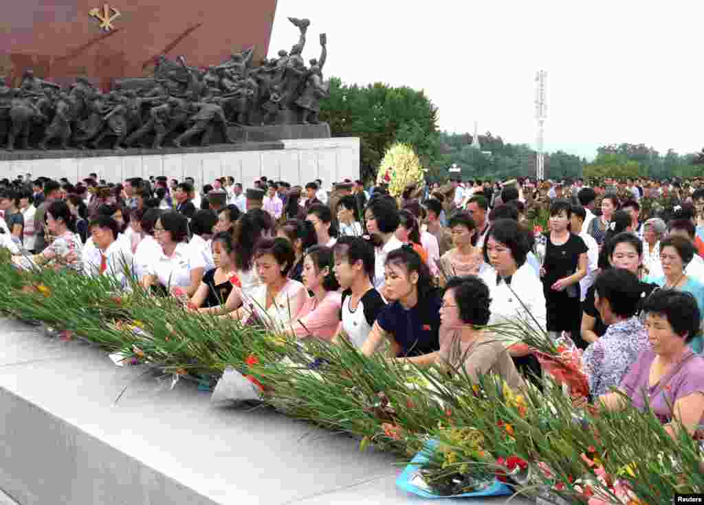 김일성 주석의 사망 23주기인 8일 북한 주민들이 평양 만수대의 김일성.김정일 동상 앞에 헌화하고 있다.
