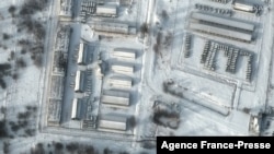 FILE - This handout satellite image released by Maxar Technologies shows armored personnel carriers and trucks at Klimovo storage facility, in Russia's Bryansk region, some 13 kilometers north of its border with Ukraine, Jan. 19, 2022.