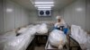Seorang pekerja dari "Hevra Kadisha," komunitas pemakaman resmi Yahudi, sedang mempersiapkan jenazah di kamar jenazah khusus korban Covid-19 di Kota Holon, dekat Tel Aviv, Israel, Senin, 12 Oktober 2020. (Foto: AP)