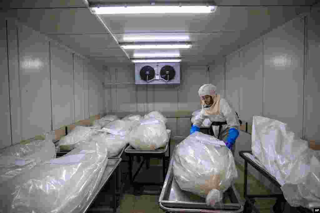 A worker from &quot;Hevra Kadisha,&quot; Israel&#39;s official Jewish burial society, prepares bodies before a funeral procession at a special morgue for COVID-19 victims,&nbsp;in the central Israeli city of Holon, near Tel Aviv.