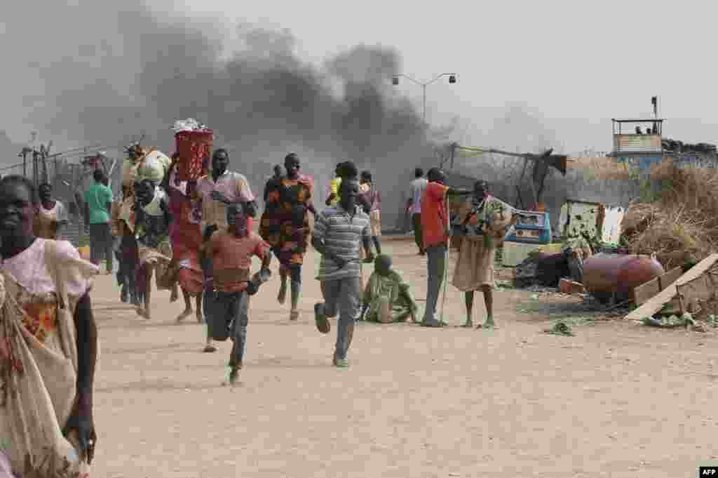 South Sudanese civilians flee fighting in an United Nations base in the northeastern town of Malakal, where gunmen opened fire on civilians sheltering inside, killing at least five people.