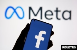 새 회사명 '메타'를 배경으로 휴대전화에 페이스북 로고가 뜨고 있다.