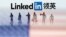 FILE - Small toy figures are seen between displayed U.S. flag and Linkedin logo in this illustration picture.