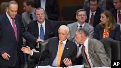 From left, Sen. Chuck Schumer, D-N.Y., standing, Sen. Orrin G. Hatch, R-Utah, and Sen. Chuck Grassley, R-Iowa, confer as the Senate Judiciary Committee meets on immigration reform on Capitol Hill in Washington, Thursday, May 9, 2013.