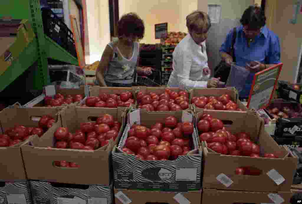 Para perempuan memilih tomat Belanda di sebuah toserba di pusat kota Moskow, 7 Agustus 2014. Pemerintah Rusia telah melarang semua impor daging, ikan, susu dan produk susu, buah-buahan, sayur mayur dari Amerika Serikat, Uni Eropa, Australia, Kanada dan Norwegia, seperti diumumkan oleh Perdana Menteri Dmitry Medvedev pada 7 Agustus 2014.