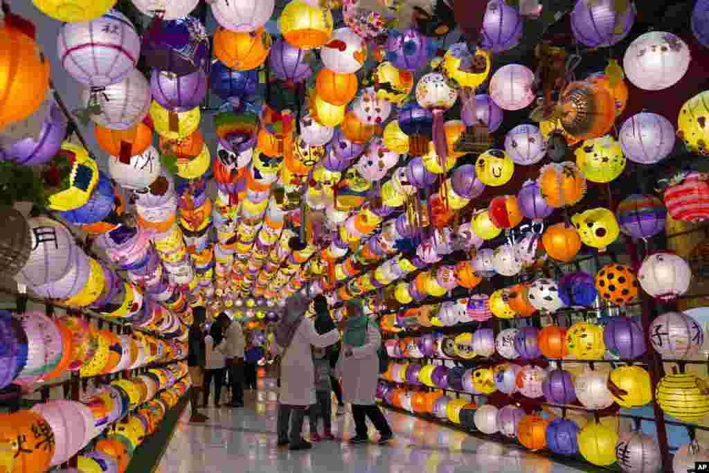 Muslim shoppers take a picture of lantern decoration for Mid-Autumn Festival at a shopping mall in Kuala Lumpur, Malaysia, Sept. 14, 2019.