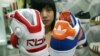 A saleswoman holds up athletic shoes by Reebok and Adidas in Taipei August 4, 2005.