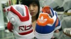 Một người bán hàng trình bày những chiếc giày của Reebok và Adidas ở Đài Bắc. Công ty Pou Yuen của Đài Loan, chuyên sản xuất giày dép, bị phán quyết phải trả tiền bồi thường cho các công nhân của họ sau khi đóng cửa nhà máy ở Campuchia.