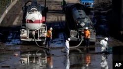 A work crew cleans up an area of Highway 101 that flooded in Montecito, Calif., Jan. 12, 2018. 