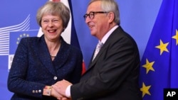 European Commission President Jean-Claude Juncker, right, greets British Prime Minister Theresa May at EU headquarters in Brussels, Nov. 24, 2018. 