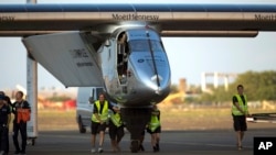 FILE - Ground crew push the Solar Impulse 2, a solar-powered airplane, toward the hangar after landing at the Kalaeloa Airport in Kapolei, Hawaii, July 3, 2015. 