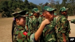 In this photo taken on Monday, Feb. 13, 2012, recruits of the Kachin Independence Army, one of the country's largest armed ethnic groups, receive training from a female instructor, left, at a military camp near Laiza.