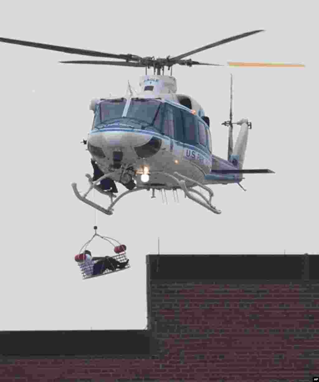 16일 미국 워싱턴 해군시설 위를 날고 있는 경찰 헬리콥터가 총격 사건의 피해자로 추정되는 사람을 실어나르고 있다.