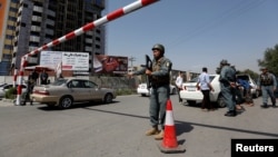 An Afghan police officer inspects vehicles at a checkpoint in Kabul, Afghanistan, Aug. 6, 2017. 