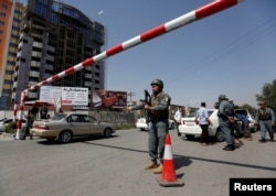 An Afghan police officer inspects vehicles at a checkpoint in Kabul, Aug. 6, 2017.