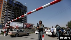 FILE - An Afghan police officer inspects vehicles at a checkpoint in Kabul, Afghanistan, Aug. 6, 2017.