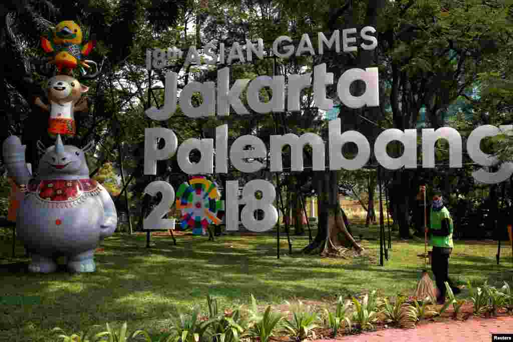 Seorang pekerja di depan logo Asian Games 2018 yang akan digelar di Jakarta dan Palembang, Jakarta, 17 September 2017. (Foto: Reuters)