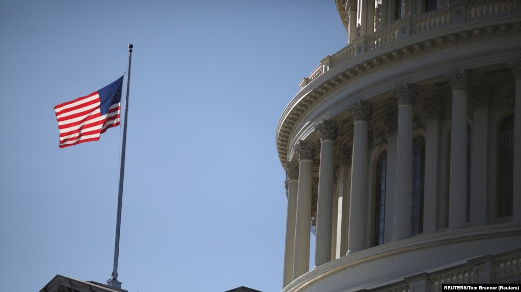 USA, Washington, The American Flag flies at the U.S. Capitol
