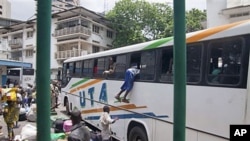 With possessions balanced on their heads, about 1,000 people frantically crowded around buses rented by Mali to evacuate its citizens from Abidjan, Ivory Coast, including a Malian man climbing into the window of a bus, March 25, 2011