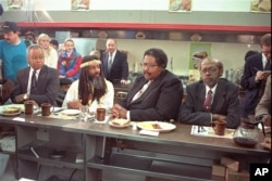 The four black men who were denied service at the Woolworth store in Greensboro, NC thirty years ago, take their places at the same lunch counter to recreate their sit-in, Feb. 2, 1990.