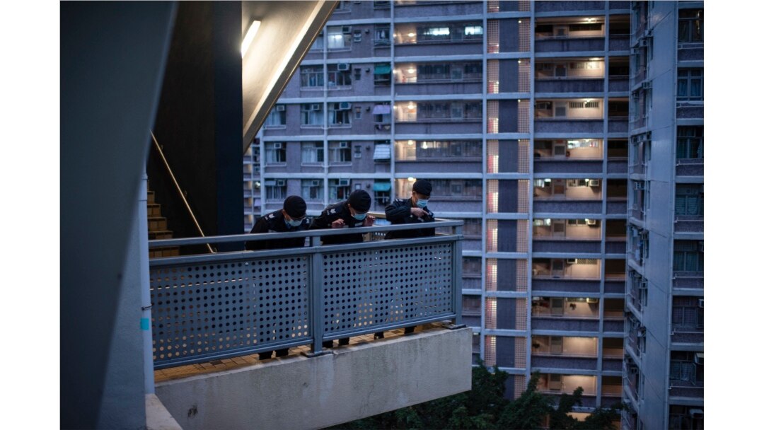 Polisi berpatroli di area kompleks perumahan umum Kwai Chung Estate di Hong Kong yang di-lockdown di tengah menrebaknya varian omicron COVID-19, 22 Januari 2022. (Louise Delmotte/AFP)